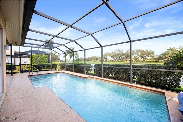 view of swimming pool with a patio area and a lanai