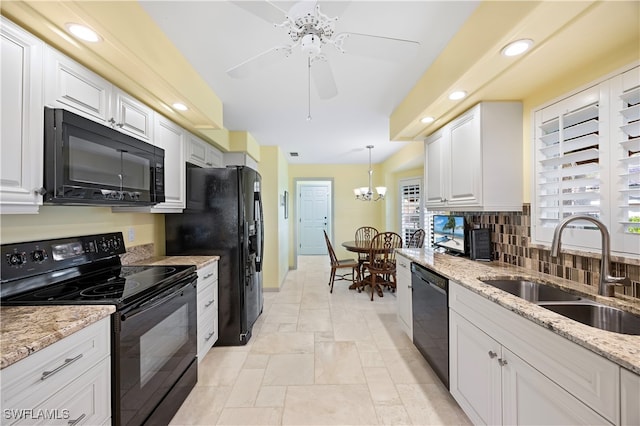 kitchen with pendant lighting, black appliances, white cabinets, sink, and light stone counters