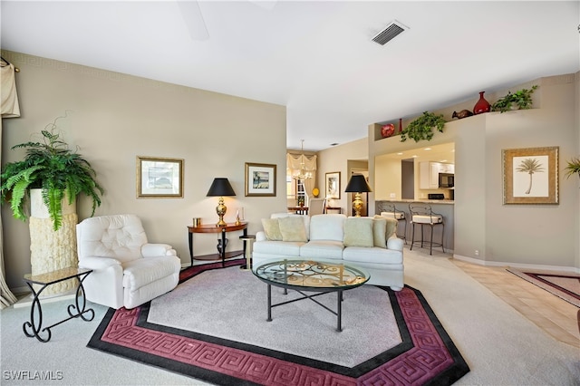 living room with light colored carpet and a notable chandelier