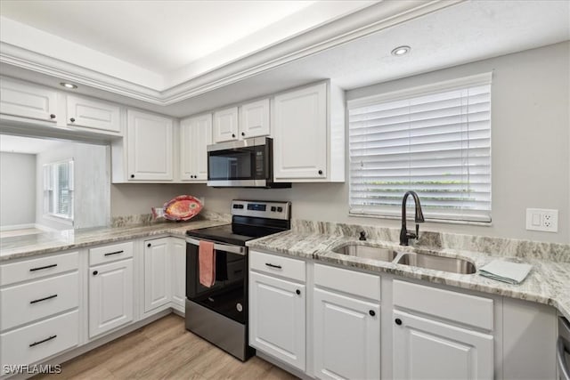4231 SE 19th Pl Unit 1J, Cape Coral, FL 33904 - kitchen featuring stainless steel appliances, white cabinetry, healthy amount of natural light, light wood-style floors, and recessed lighting