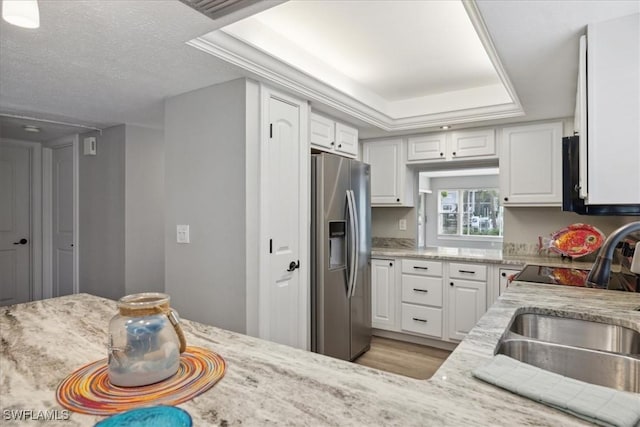 4231 SE 19th Pl Unit 1J, Cape Coral, FL 33904 - kitchen featuring stainless steel refrigerator with ice dispenser, white cabinetry, light stone counters, and a tray ceiling