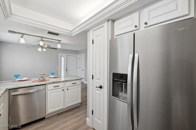 4231 SE 19th Pl Unit 1J, Cape Coral, FL 33904 - kitchen with stainless steel appliances, white cabinets, light wood-style flooring, ceiling fan, and a tray ceiling