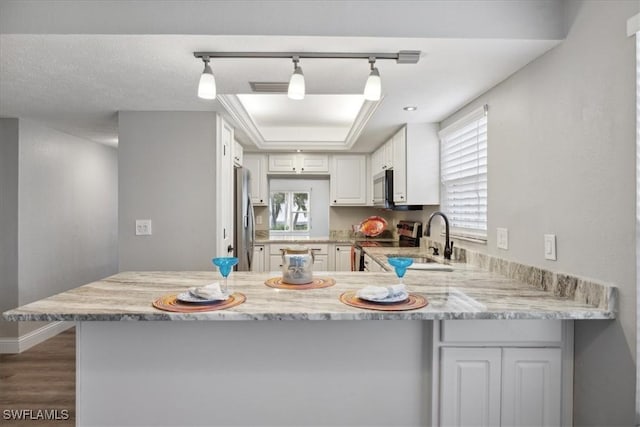 4231 SE 19th Pl Unit 1J, Cape Coral, FL 33904 - kitchen featuring appliances with stainless steel finishes, a peninsula, dark wood-style floors, a sink, and white cabinets