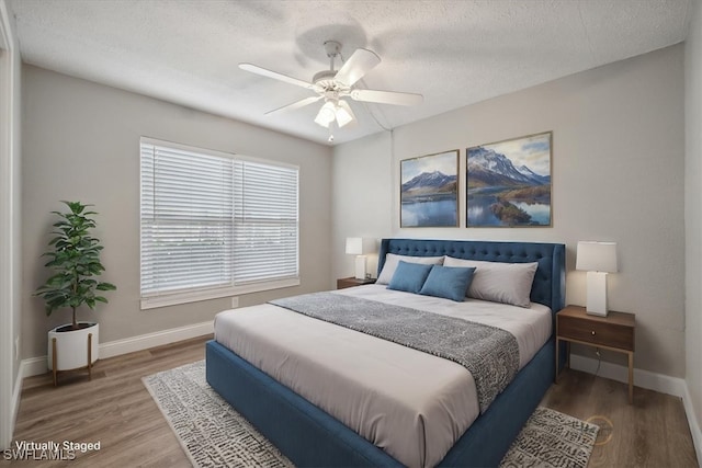 4231 SE 19th Pl Unit 1J, Cape Coral, FL 33904 - bedroom featuring baseboards, wood finished floors, a textured ceiling, and ceiling fan