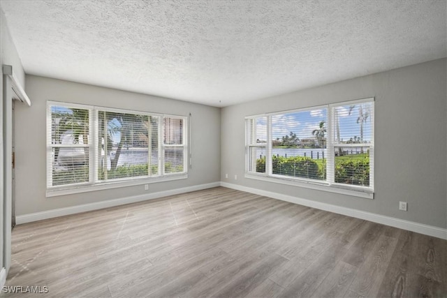 4231 SE 19th Pl Unit 1J, Cape Coral, FL 33904 - empty room with baseboards, wood finished floors, and a textured ceiling