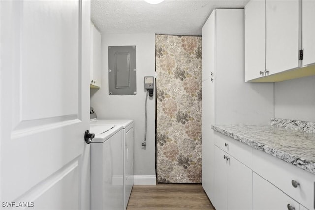 4231 SE 19th Pl Unit 1J, Cape Coral, FL 33904 - laundry area featuring electric panel, cabinet space, washer and clothes dryer, light wood-style floors, and a textured ceiling