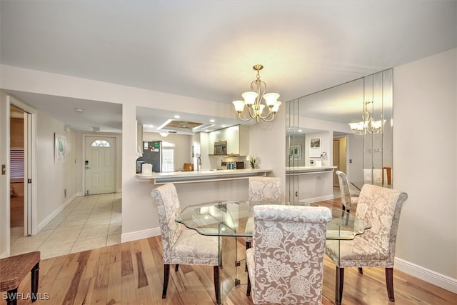 dining space featuring light hardwood / wood-style floors and a chandelier