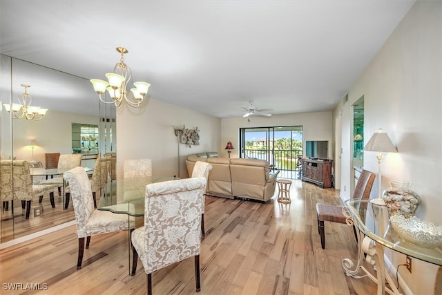 dining room featuring ceiling fan with notable chandelier and light hardwood / wood-style flooring