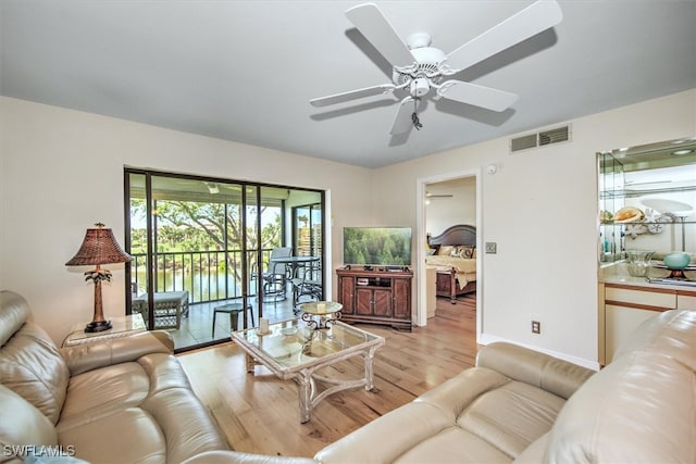 living room featuring ceiling fan and light hardwood / wood-style floors