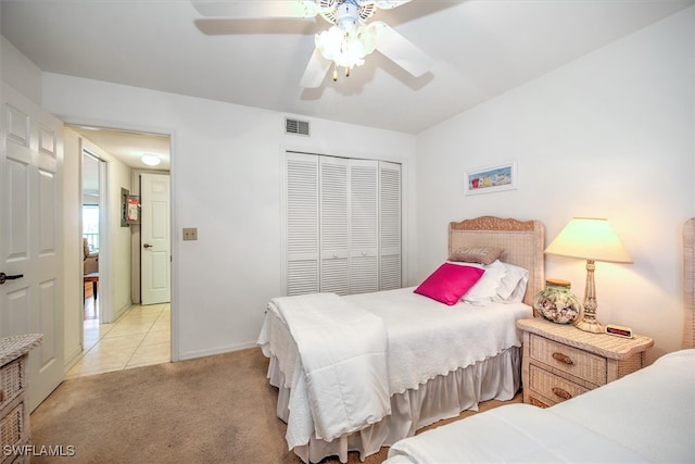 bedroom featuring ceiling fan, light colored carpet, and a closet