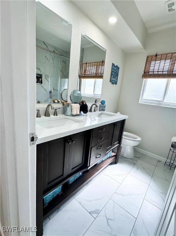 bathroom with a shower with door, vanity, a healthy amount of sunlight, and toilet