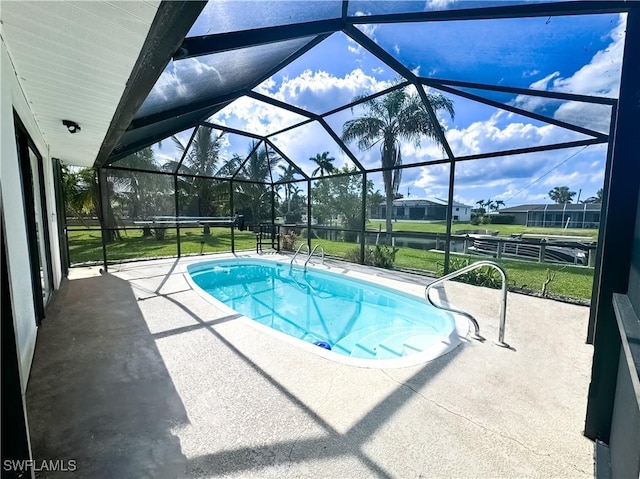 view of swimming pool featuring a lanai, a patio, and a lawn