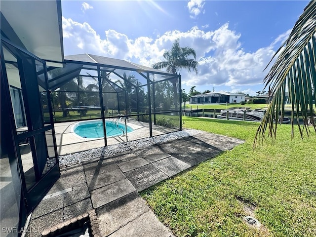 view of swimming pool featuring a yard, a patio area, and glass enclosure