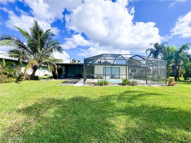 back of house with a patio area, a lawn, and glass enclosure