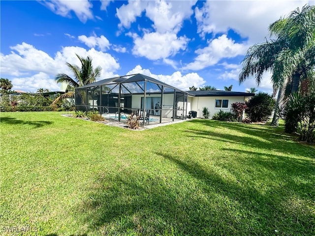 rear view of property featuring a yard, a lanai, and a patio