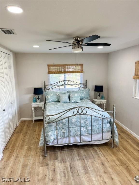 bedroom with hardwood / wood-style floors, ceiling fan, and a closet