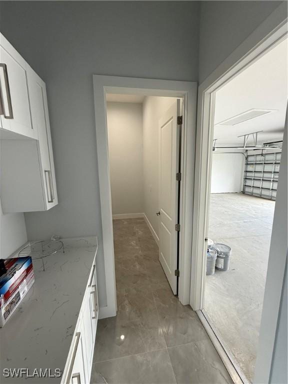 interior space with white cabinets and light stone counters