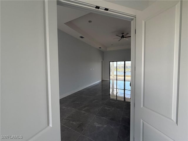 unfurnished room with a raised ceiling and ceiling fan