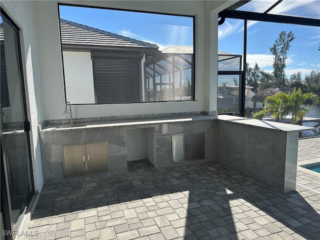 view of patio / terrace featuring a lanai