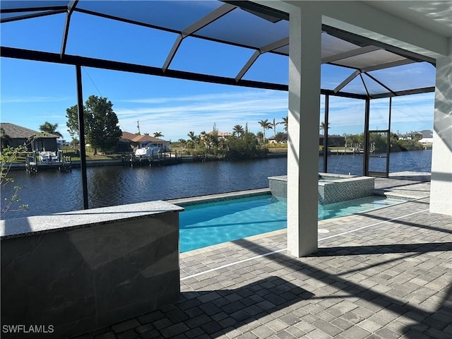 view of swimming pool featuring glass enclosure, a water view, and a patio