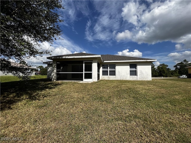 back of property with a sunroom and a yard