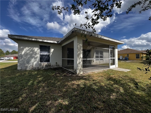 back of property with a sunroom and a yard