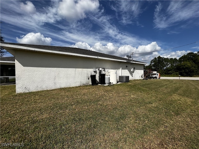 view of side of property with cooling unit and a yard