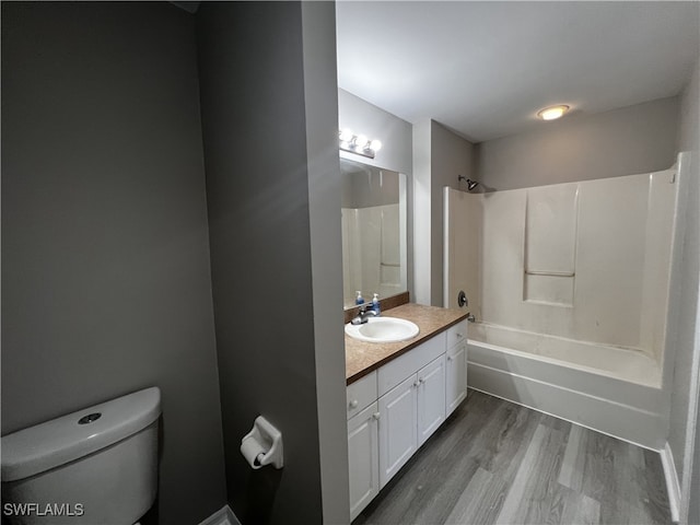 full bathroom featuring toilet, washtub / shower combination, vanity, and wood-type flooring