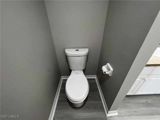 bathroom with toilet and hardwood / wood-style flooring