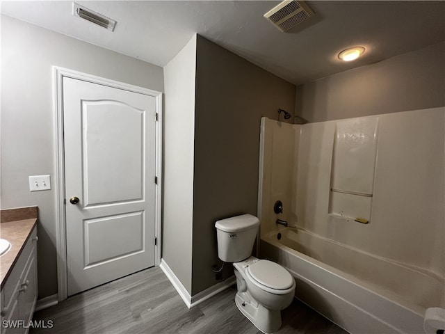 full bathroom featuring hardwood / wood-style floors, vanity, bathing tub / shower combination, and toilet