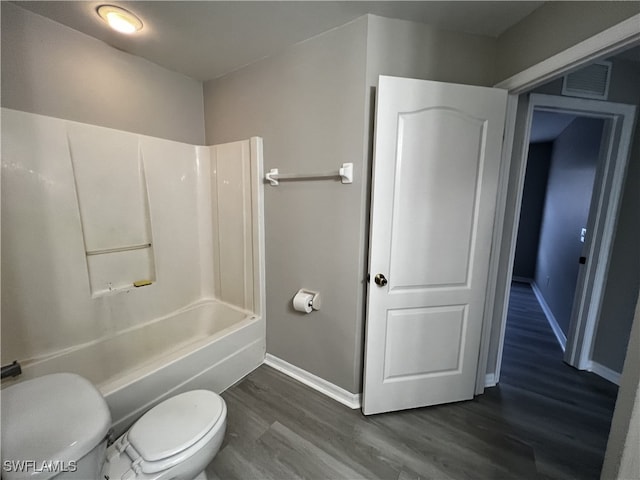 bathroom with toilet, shower / bath combination, and wood-type flooring