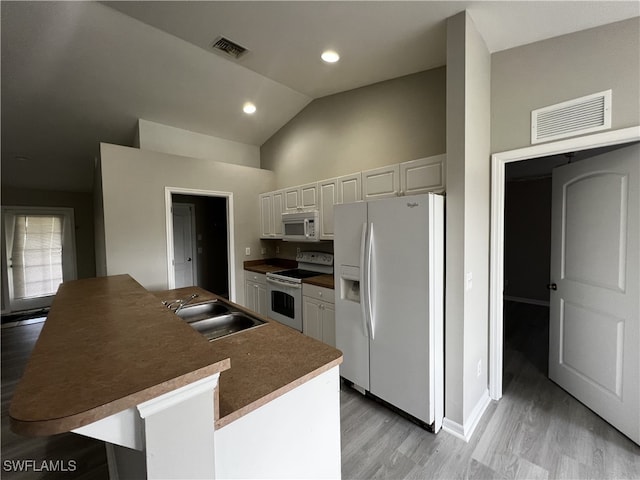 kitchen featuring white cabinetry, sink, light hardwood / wood-style floors, white appliances, and a center island