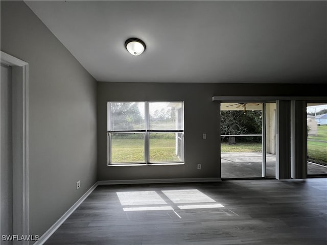 unfurnished room featuring dark wood-type flooring and ceiling fan