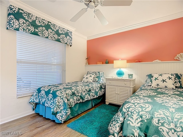 bedroom featuring ceiling fan, wood-type flooring, and ornamental molding