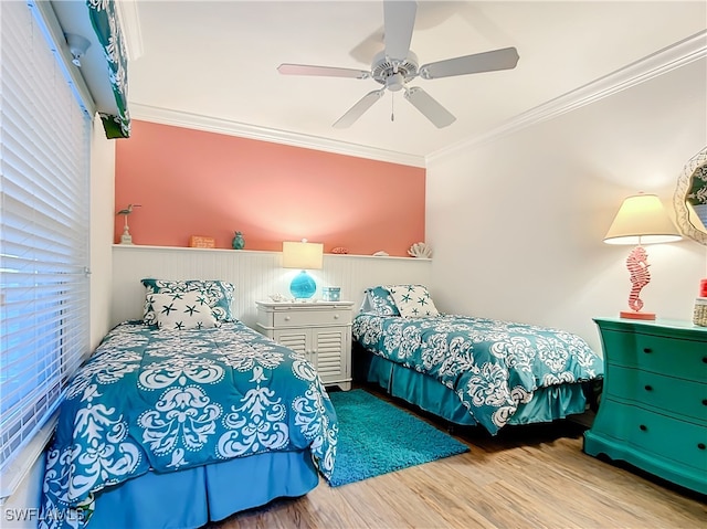 bedroom featuring ceiling fan, crown molding, and light hardwood / wood-style floors