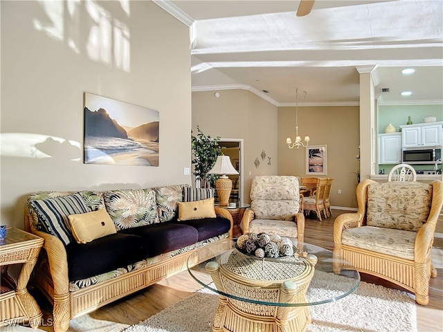 living room with ornate columns, a chandelier, crown molding, and wood-type flooring