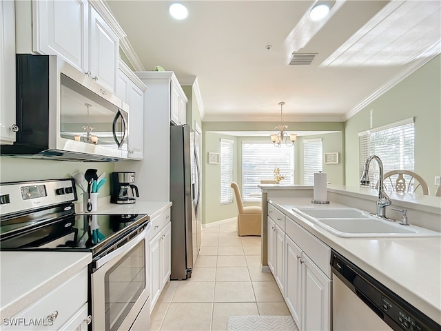 kitchen with white cabinets, appliances with stainless steel finishes, a chandelier, and sink