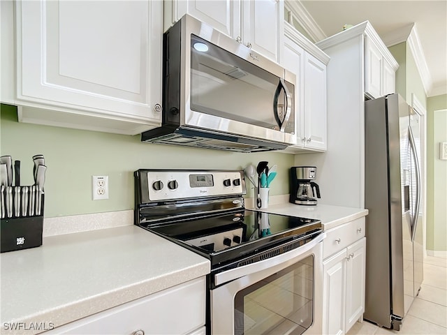 kitchen with white cabinetry, light tile patterned flooring, ornamental molding, and appliances with stainless steel finishes