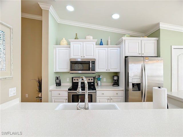 kitchen featuring white cabinets, appliances with stainless steel finishes, vaulted ceiling, and ornamental molding