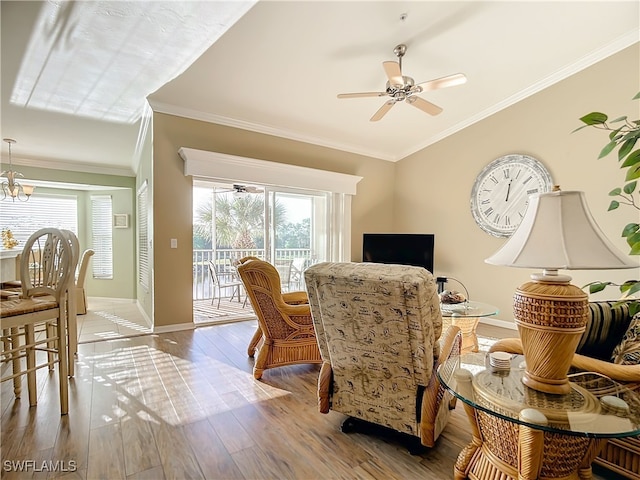 dining area featuring ceiling fan with notable chandelier, wood-type flooring, and crown molding