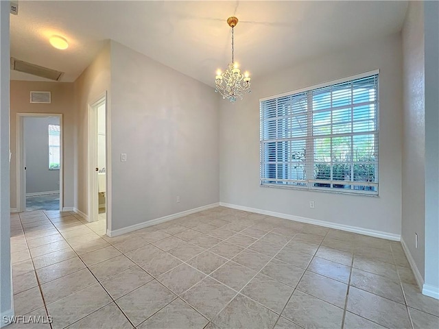 spare room with light tile patterned floors, an inviting chandelier, and a healthy amount of sunlight