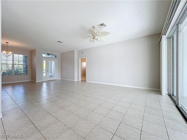 tiled spare room featuring ceiling fan with notable chandelier and french doors