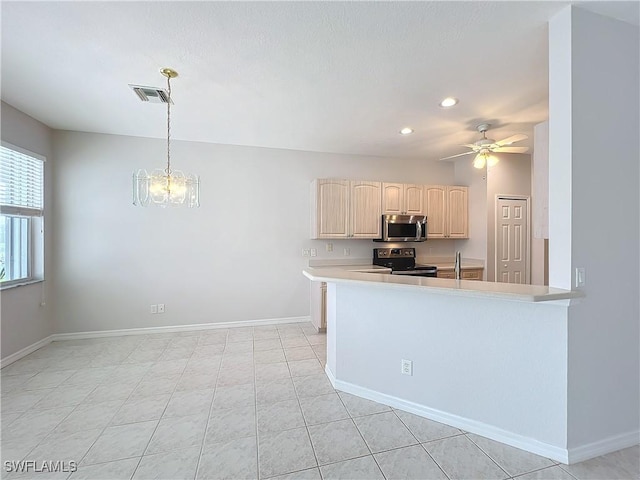 kitchen featuring ceiling fan with notable chandelier, kitchen peninsula, hanging light fixtures, and appliances with stainless steel finishes