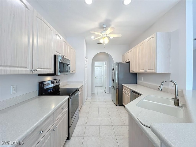 kitchen with ceiling fan, sink, light tile patterned floors, and stainless steel appliances