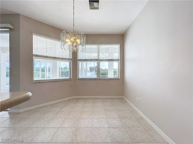 unfurnished dining area with a chandelier and light tile patterned floors