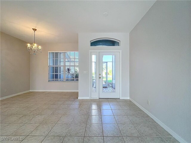 entryway with light tile patterned floors and an inviting chandelier