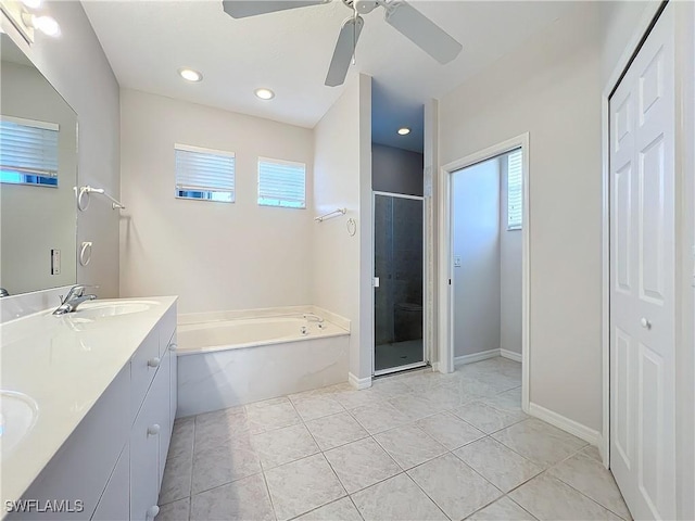 bathroom with vanity, ceiling fan, plus walk in shower, and a healthy amount of sunlight