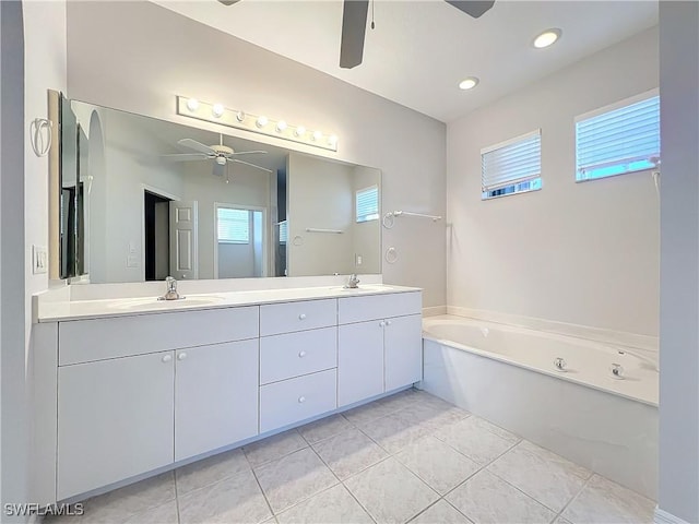 bathroom featuring tile patterned floors, vanity, ceiling fan, and a washtub