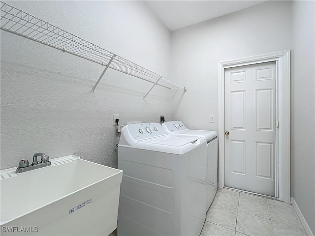 washroom with washer and dryer, light tile patterned floors, and sink