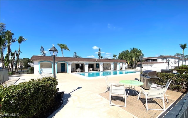 view of pool with area for grilling and a patio